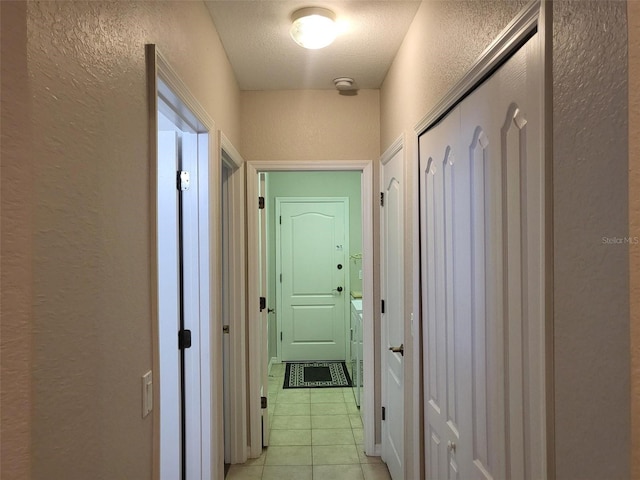 201 Auburn Woods Cir, Venice, FL 34292 - hallway featuring a textured wall, light tile patterned floors, and a textured ceiling