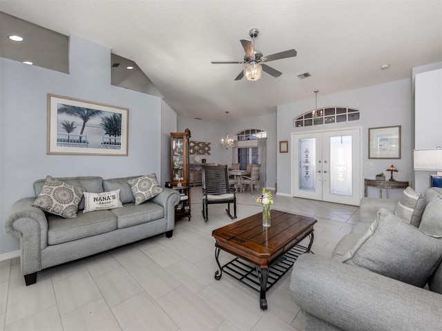 living room featuring ceiling fan with notable chandelier, a textured ceiling, and french doors