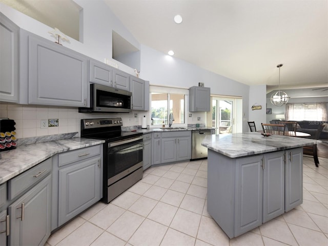 kitchen featuring appliances with stainless steel finishes, tasteful backsplash, a kitchen island, and gray cabinetry