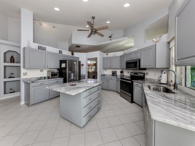 kitchen featuring gray cabinetry, sink, a center island, and appliances with stainless steel finishes