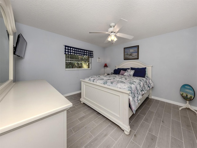 bedroom featuring wood-type flooring, a textured ceiling, and ceiling fan