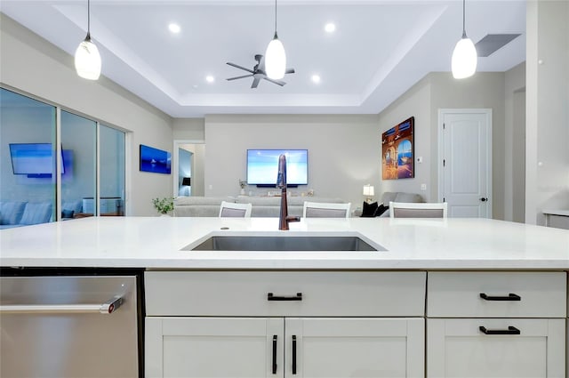 kitchen featuring hanging light fixtures, white cabinets, sink, and stainless steel dishwasher