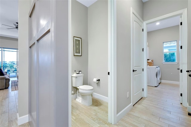 bathroom featuring toilet, washer and clothes dryer, wood-type flooring, and ceiling fan