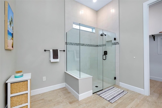 bathroom with hardwood / wood-style floors and an enclosed shower