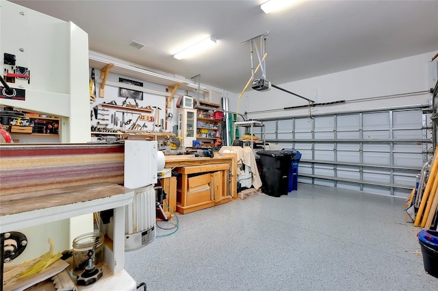 garage featuring a garage door opener and a workshop area