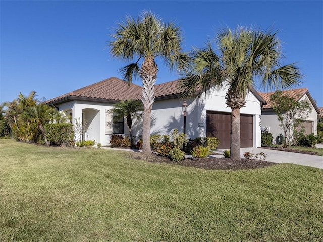 mediterranean / spanish house with a front lawn and a garage