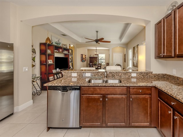 kitchen with kitchen peninsula, stainless steel appliances, a raised ceiling, ceiling fan, and sink