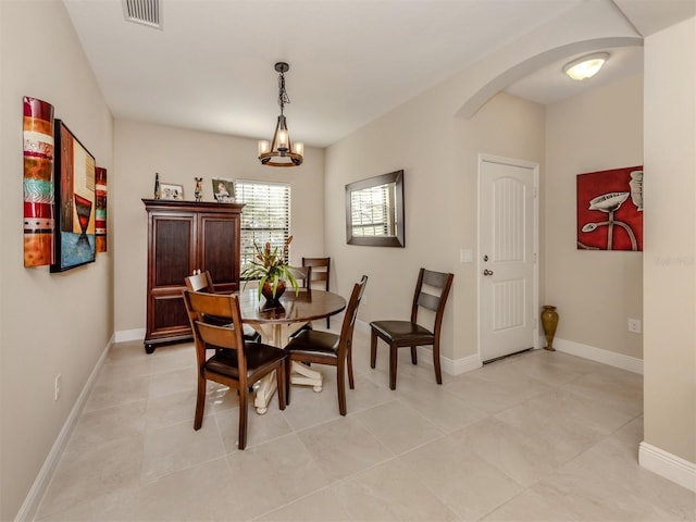 dining room with light tile patterned floors and a notable chandelier