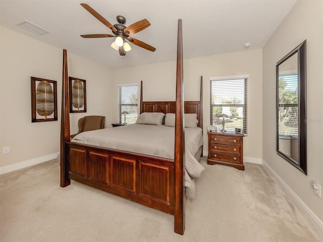 bedroom with light colored carpet, ceiling fan, and multiple windows