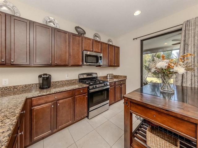 kitchen featuring appliances with stainless steel finishes, light stone countertops, and light tile patterned floors