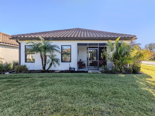 rear view of property featuring a lawn