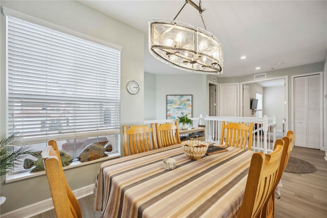 dining area featuring an inviting chandelier and wood-type flooring