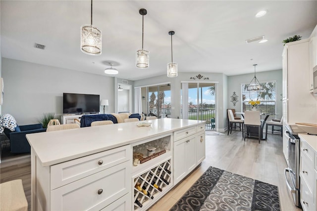 kitchen featuring electric stove, white cabinetry, and pendant lighting