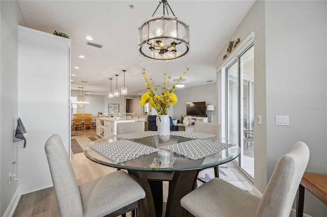 dining room featuring light hardwood / wood-style flooring and a notable chandelier