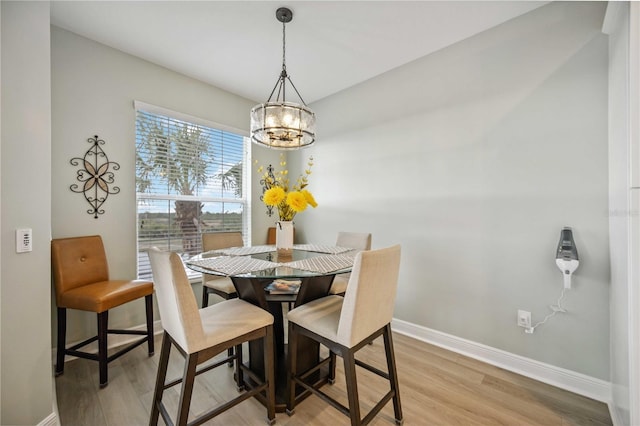 dining space with a notable chandelier and light wood-type flooring