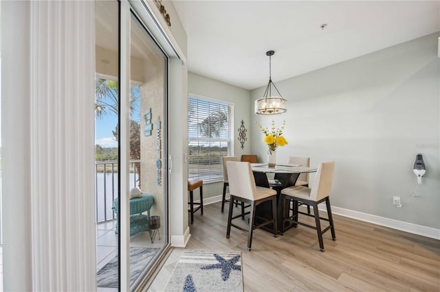 dining area featuring light hardwood / wood-style flooring and a chandelier