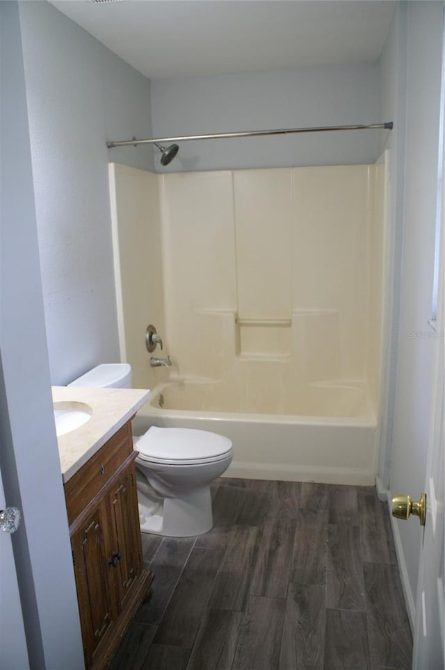 full bathroom featuring hardwood / wood-style flooring, shower / washtub combination, vanity, and toilet