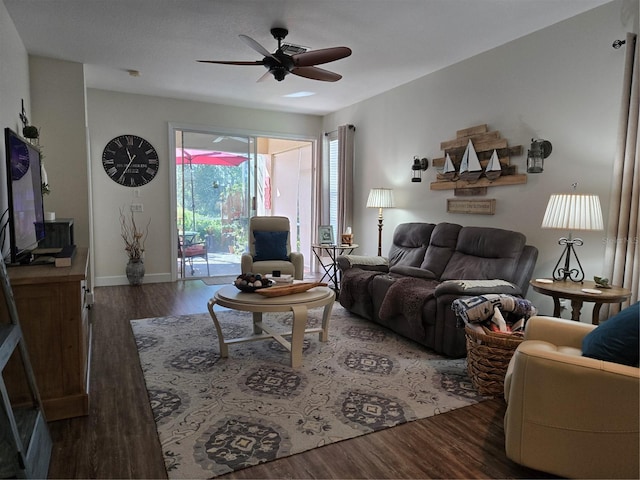 living room featuring ceiling fan and dark wood-type flooring