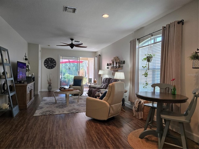 living room featuring a textured ceiling, plenty of natural light, dark wood-type flooring, and ceiling fan