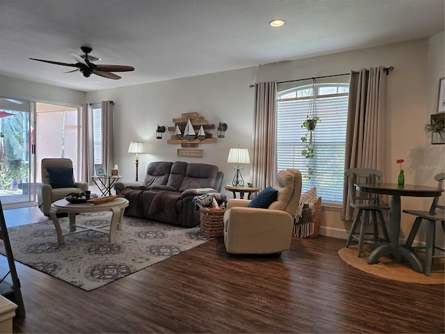 living room featuring ceiling fan and dark hardwood / wood-style floors