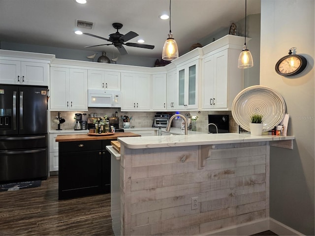 kitchen featuring white cabinetry, black refrigerator with ice dispenser, tasteful backsplash, and decorative light fixtures