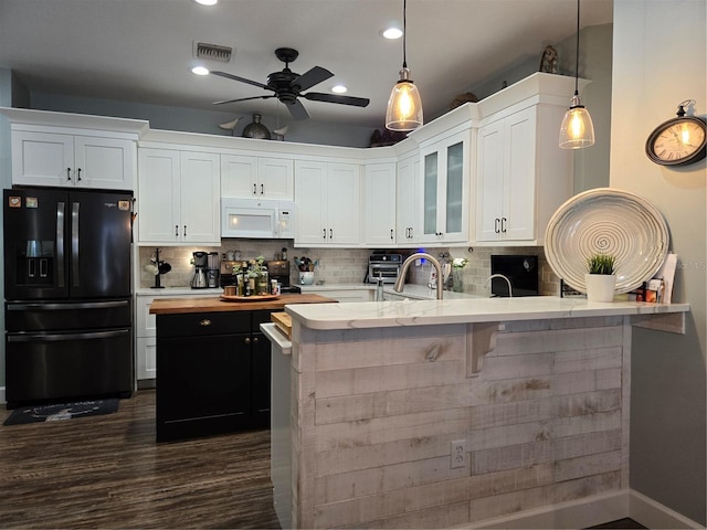 kitchen featuring black fridge with ice dispenser, white cabinets, and decorative light fixtures