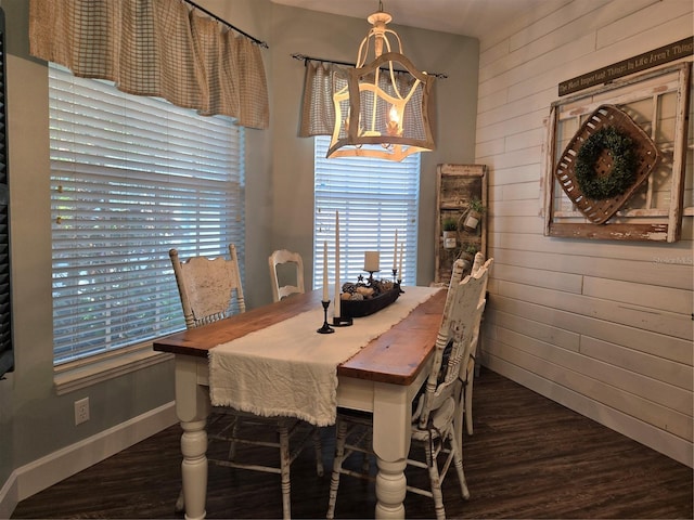 dining space featuring wooden walls and dark wood-type flooring