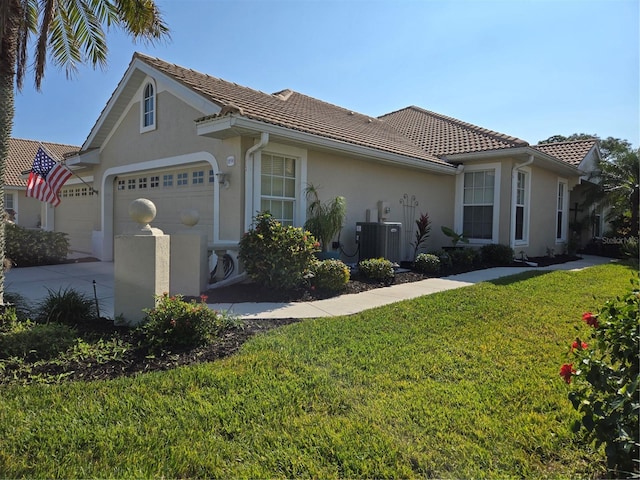 view of front of home with central AC unit, a garage, and a front yard