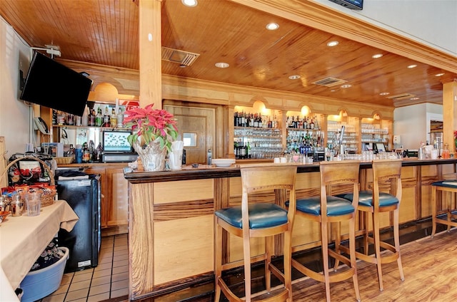 bar featuring light wood-type flooring and wooden ceiling