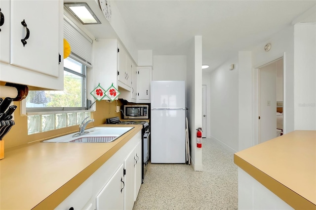 kitchen with sink, white cabinets, and appliances with stainless steel finishes