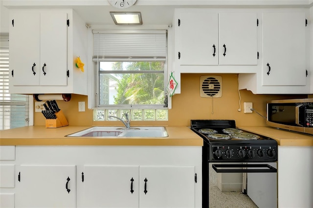 kitchen with sink, black electric range, and white cabinets