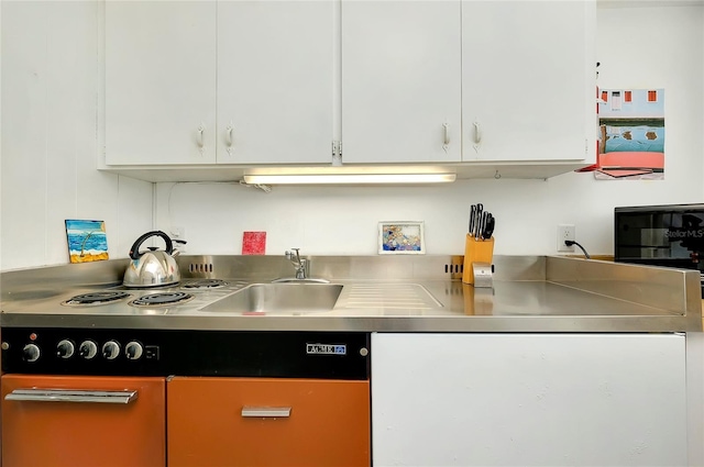 kitchen featuring white cabinetry, sink, and stainless steel counters