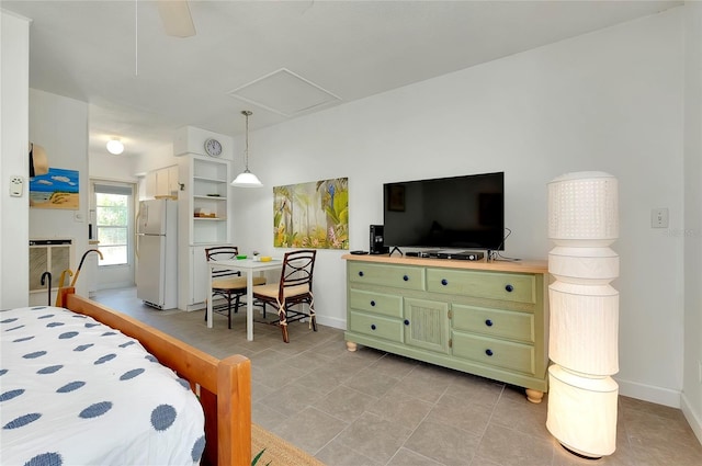 bedroom with white refrigerator and light tile patterned floors