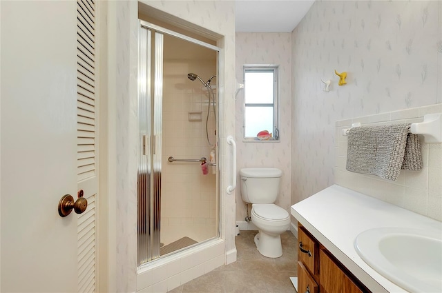 bathroom featuring vanity, toilet, and a shower with shower door