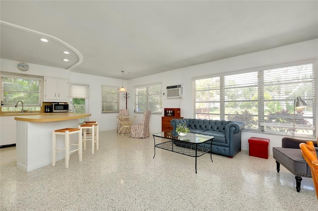 living room featuring sink and an AC wall unit