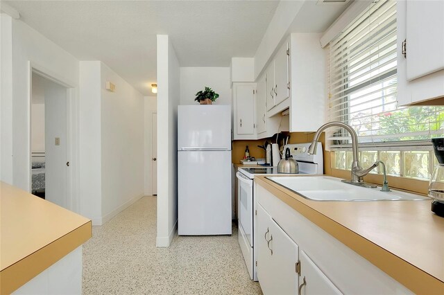 kitchen with white cabinetry, white appliances, and sink