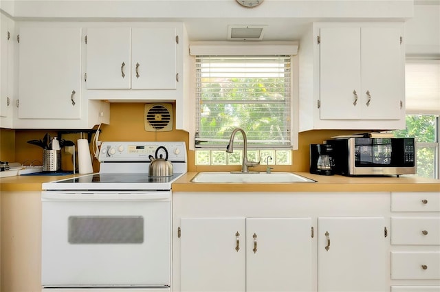 kitchen featuring sink, white cabinets, and white range with electric stovetop