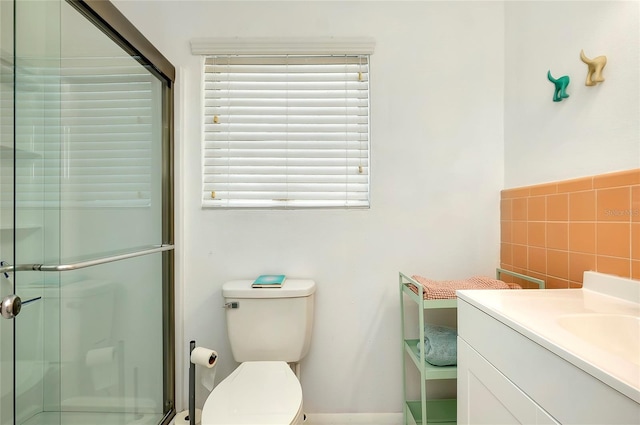 bathroom featuring a shower with door, vanity, backsplash, and toilet