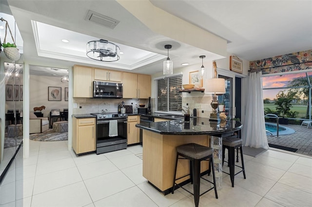 kitchen featuring pendant lighting, appliances with stainless steel finishes, backsplash, a raised ceiling, and light brown cabinets