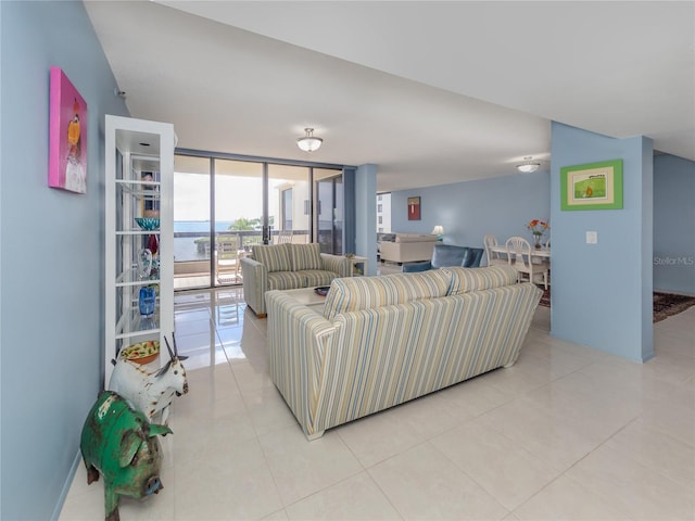 living room featuring a water view, light tile patterned flooring, and a wall of windows