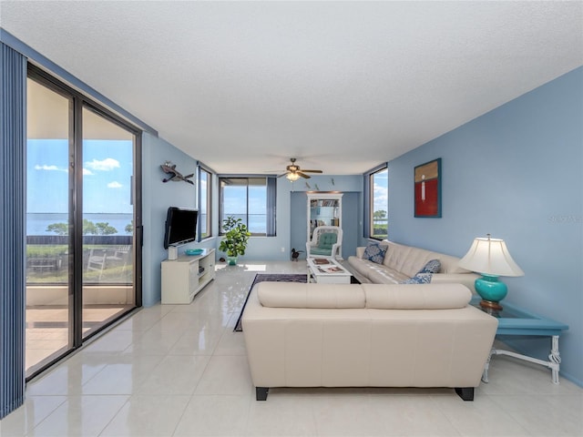 tiled living room with a textured ceiling and ceiling fan