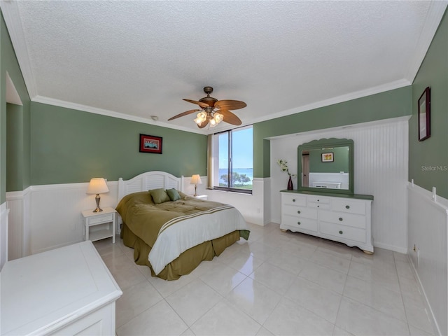 bedroom with ceiling fan, ornamental molding, a textured ceiling, and light tile patterned floors