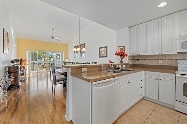 kitchen featuring kitchen peninsula, sink, white cabinets, and white appliances