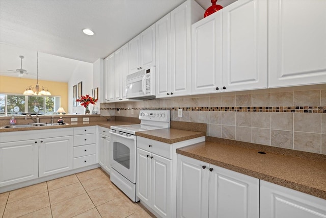 kitchen with white appliances, backsplash, sink, light tile patterned floors, and white cabinetry