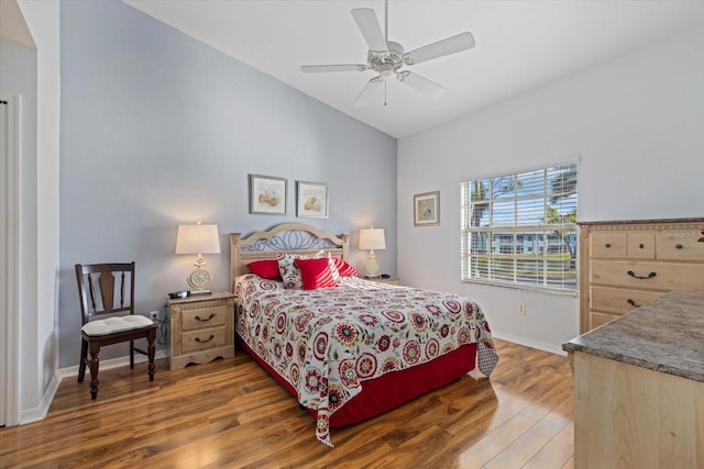 bedroom with dark hardwood / wood-style flooring, ceiling fan, and lofted ceiling