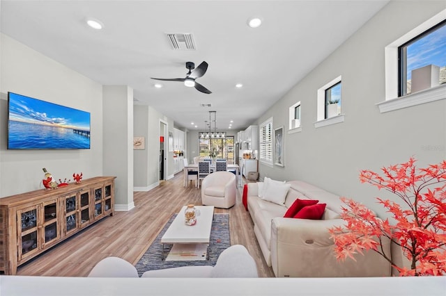 living room featuring light hardwood / wood-style flooring and ceiling fan