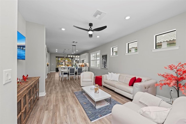 living room with ceiling fan and light wood-type flooring