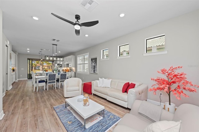 living room featuring ceiling fan and light hardwood / wood-style flooring