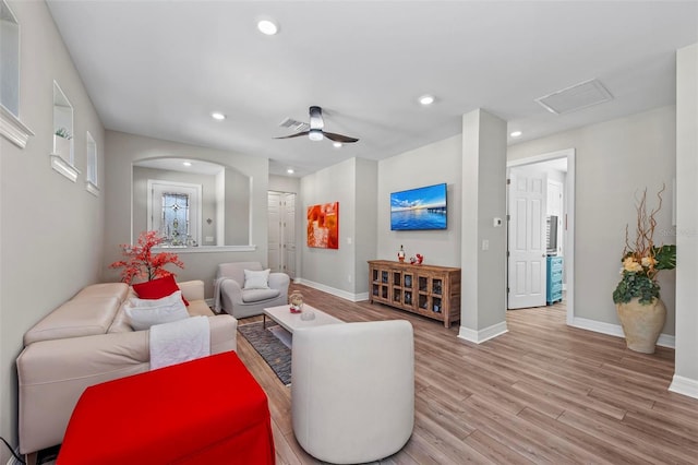 living room with light hardwood / wood-style flooring and ceiling fan