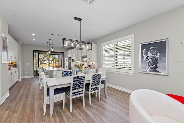 dining area with a wealth of natural light and light hardwood / wood-style floors